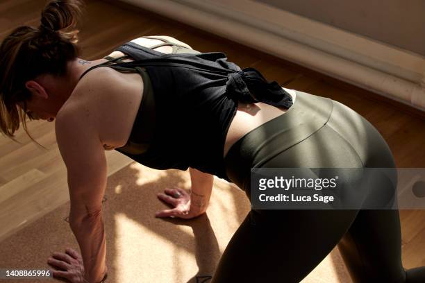 athletic female  practising yoga in a sunny studio - leggings foto e immagini stock