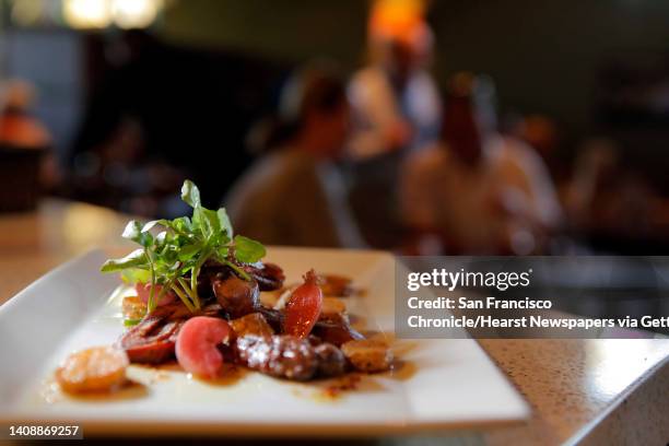 The Grilled Lambs Tongue with whole grain mustard vinaigrette, watercress, and pickled radishes served at Santi restaurant in Santa Rosa, Calif.,...