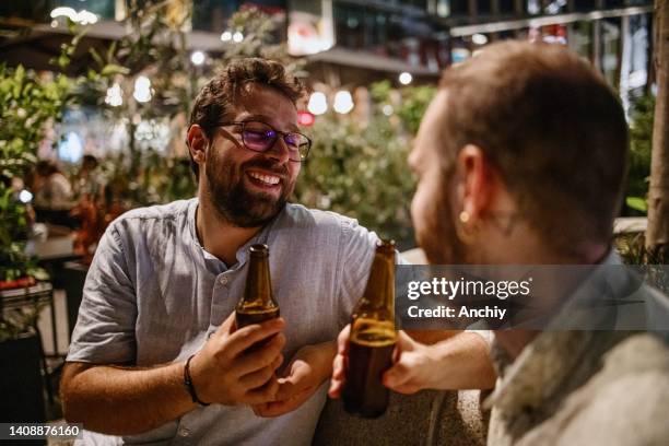 romantic gay couple drinking beer during the date night - italy beer stock pictures, royalty-free photos & images