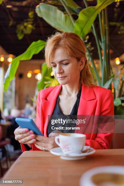 frau mit smartphone und sms im café - albanian woman stock-fotos und bilder