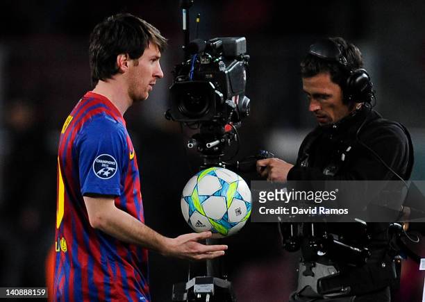 Lionel Messi of FC Barcelona holds the ball after scoring 5 goals, followed by a camera man at the end of the UEFA Champions League round of 16...