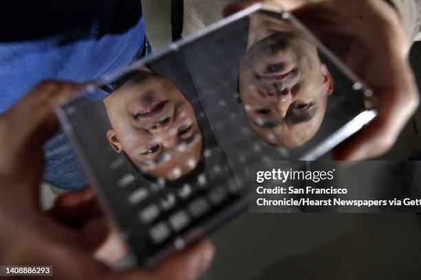 Jonathan Tang, left, and Sylvain Costes, right, the co-founders of Exogen Biotechnology, are reflected in a 96-well plate that is used for DNA...