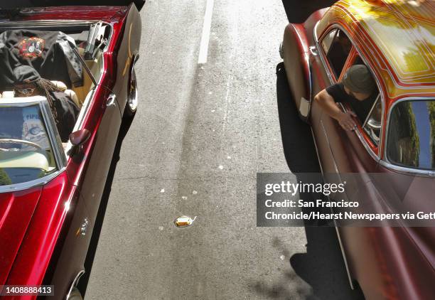 Two Low Rider cars wait on 24th Street before the start of the Carnaval Parade on Sunday. Thousands of dancers, participants and spectators converged...