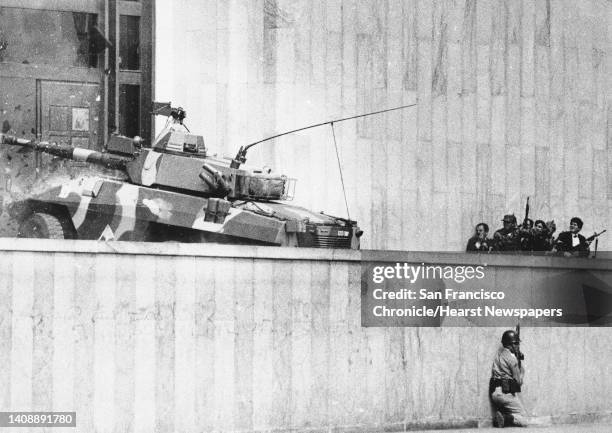 In this Nov. 6 file photo, an armored vehicle crashes through the two story wooden doors at the front entrance to the Palace of Justice in Bogota, as...