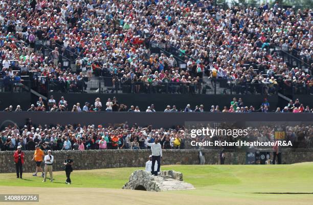 Tiger Woods of the United States acknowledges the crowd on the Swilcan Bridge on the 18th hole during Day Two of The 150th Open at St Andrews Old...