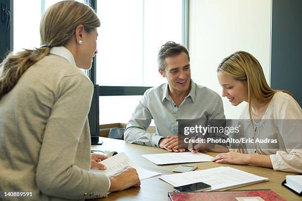 couple reading over contract in office - bank loan stockfoto's en -beelden