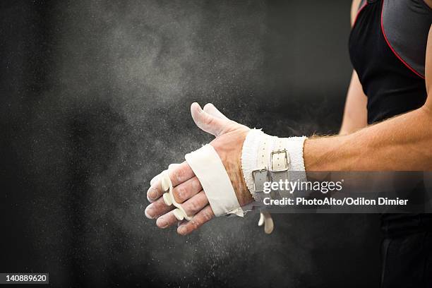 gymnast applying chalk power to hands in preparation - usa gymnastics photos et images de collection