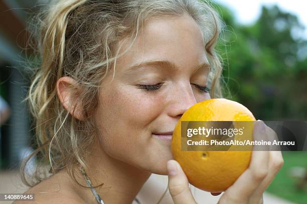 woman smelling fresh orange - instinto imagens e fotografias de stock