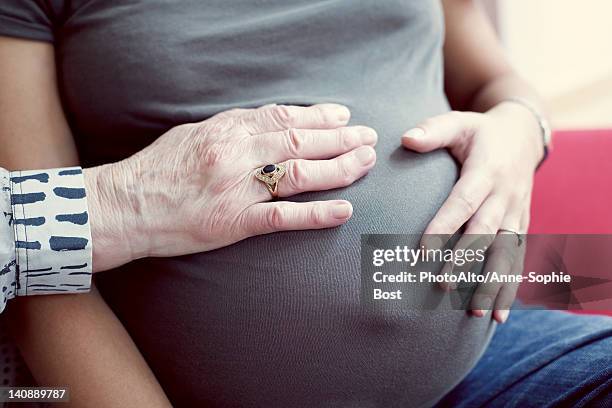 hands on pregnant woman's abdomen - anne sophie mutter stock-fotos und bilder