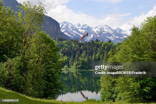 freibergsee and heini-klopfer ski jump, near oberstdorf, allgaeu alps, allgaeu, bavaria, germany - oberstdorf ski stock illustrations