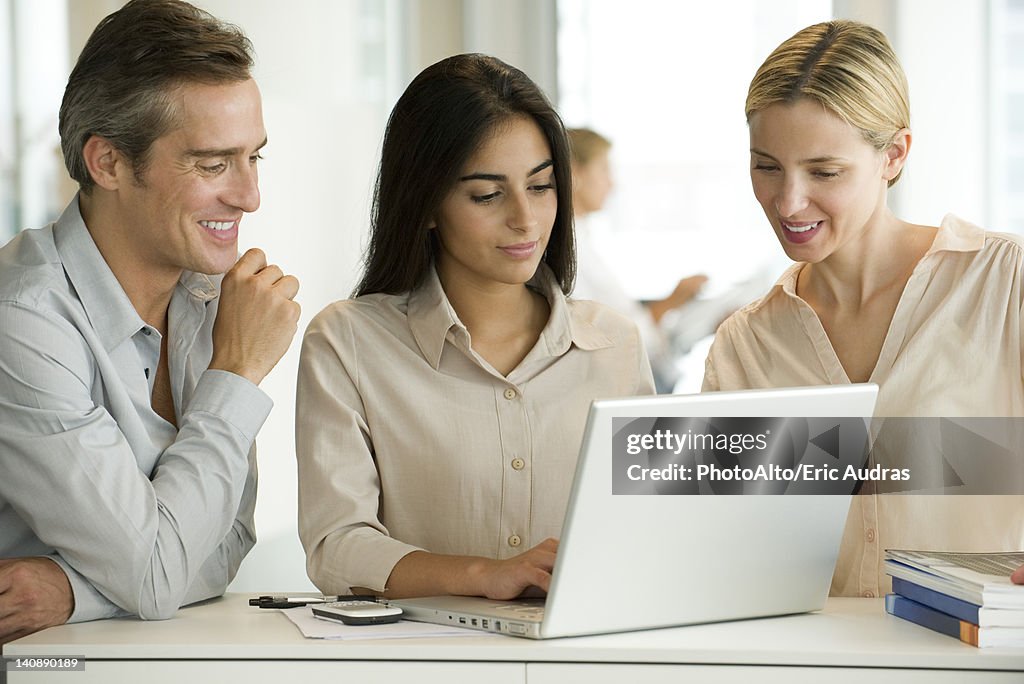 Colleagues working together on laptop computer