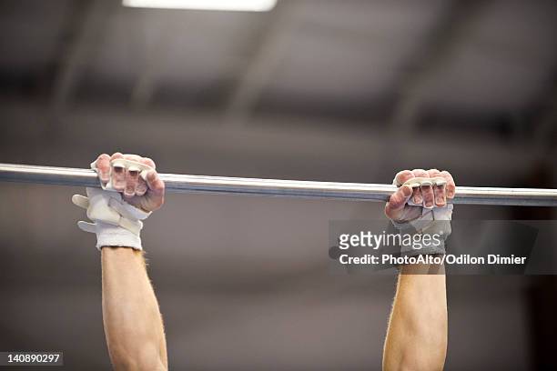 gymnast gripping horizontal bar, cropped - brug turntoestel stockfoto's en -beelden