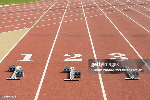 starting blocks at starting line on running track - starting block stockfoto's en -beelden