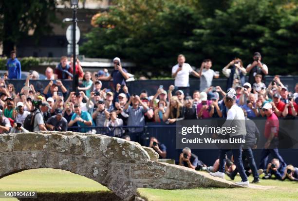 Tiger Woods of the United States acknowledges the crowd as he crosses the Swilcan Bridge during Day Two of The 150th Open at St Andrews Old Course on...