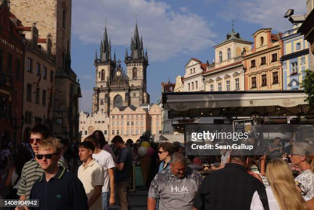 People walk on Old Town Square as Tyn Church stands behind on July 14, 2022 in Prague, Czech Republic. The Czech capital is seeing a strong rise in...
