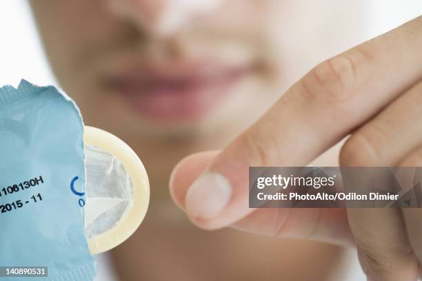 man removing condom from wrapper, cropped - condoms stock pictures, royalty-free photos & images
