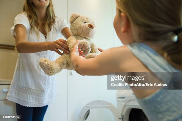 little girl receiving freshly cleaned teddy bear from mother - mama bear - fotografias e filmes do acervo