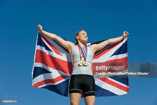 female athlete being honored on podium, holding up british flag - olympic podium stock pictures, royalty-free photos & images