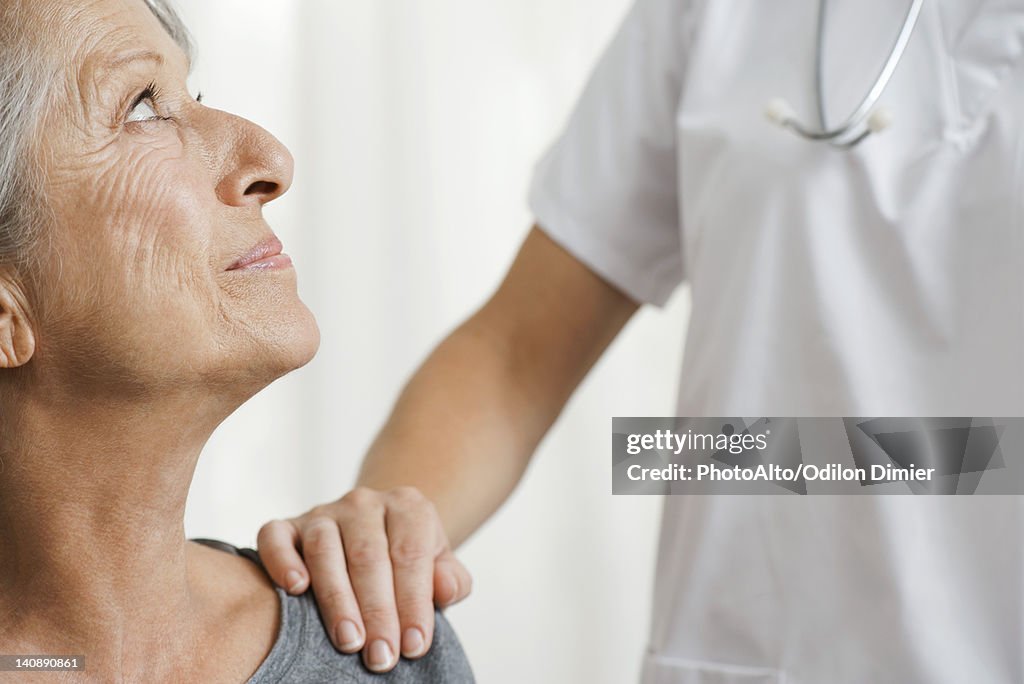 Senior woman with caring doctor, cropped