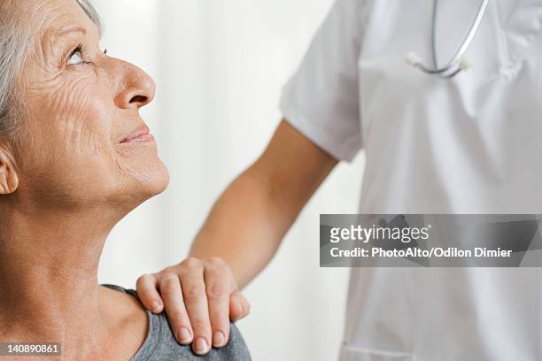 senior woman with caring doctor, cropped - hand on shoulder stock pictures, royalty-free photos & images