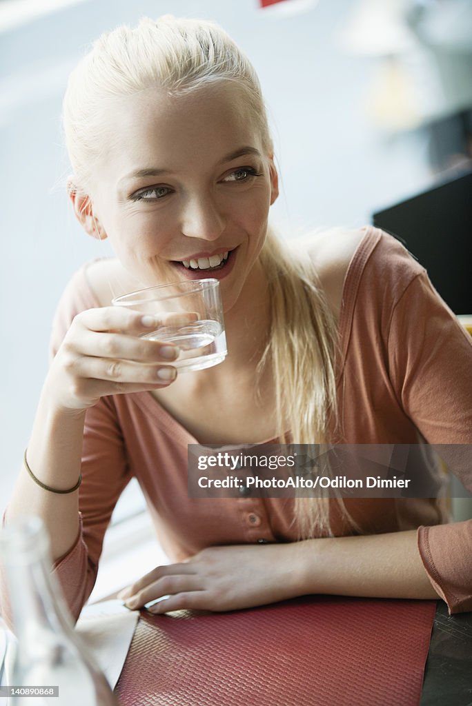 Young blond woman drinking water