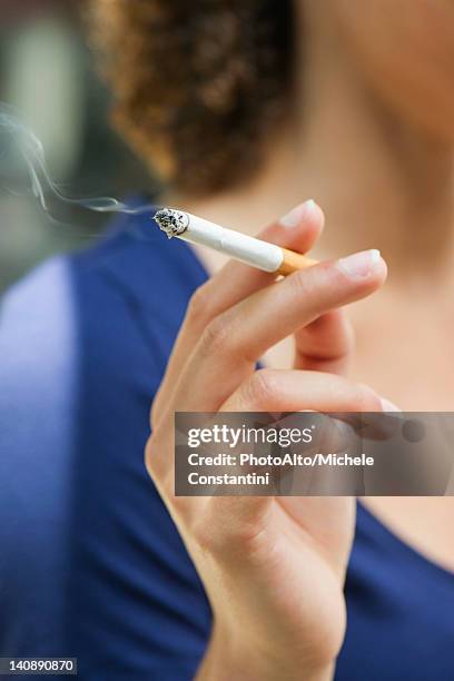 woman's hand holding lit cigarette - females smoking stock pictures, royalty-free photos & images