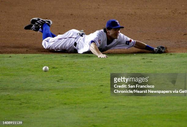 Texas Rangers second baseman Ian Kinsler can't make the play on a San Francisco Giants right fielder Andres Torres single in the third inning during...