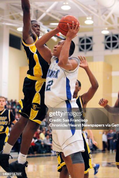 Sacred Heart's Joshua Fox tries to put up a shot in the first quarter as he is quarded by O'Dowd's Richard Longrus. Bishop O'Dowd versus Sacred Heart...