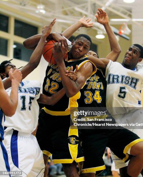 Dowd's Richard Longrus, center, comes up with a rebound and is fouled by Sacred Heart's Herman Pratt in the first quarter. Also on the play was...