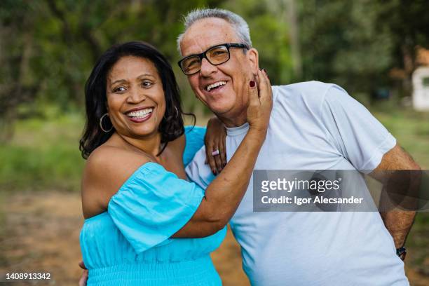 mature couple hugging outdoors - real people stockfoto's en -beelden
