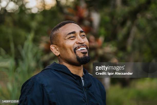 smiling latin american man in public park - man goatee stock pictures, royalty-free photos & images