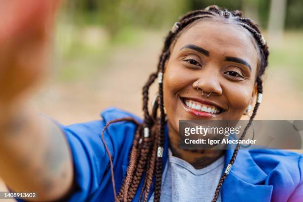 afro woman taking a selfie - real people stockfoto's en -beelden