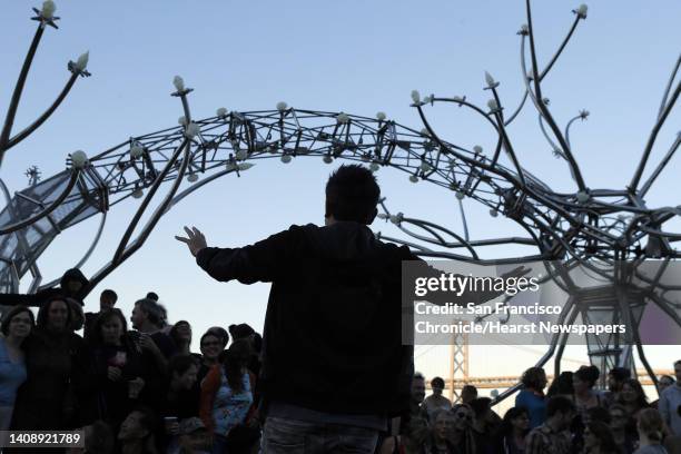 Photographer Jason Chinn, tries to get the Flaming Lotus Girls together for a group shot in front of the sculpture SOMA on Wednesday. A new steel...