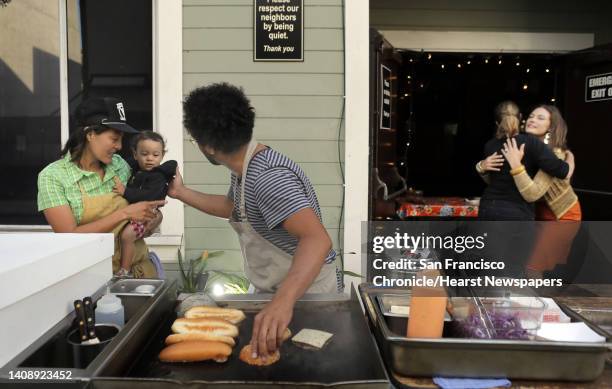 Chef Ravi Kapur, center, greets Kaylon held by his mom, assistant chef, Nana Guardia, left, as Nana's wife, Una Traynor, 2nd from right, greets...