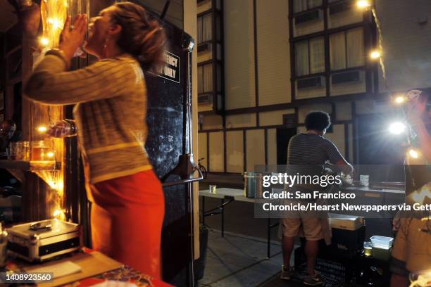 Chef Ravi Kapur, right, prepares a dish as his wife, April Storm, left, calls out to a customer at Bloodhound Bar on Thursday. Kapur is holding a...