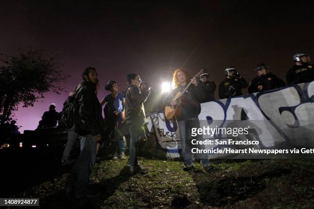 Demonstrators stand behind a barrier on Highway 24 near the 580 freeway interchange after police officers force the protest off the roadway in...