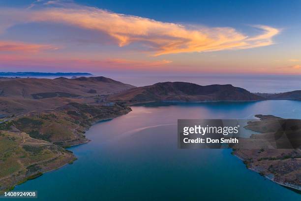 sunset lit clouds over whale rock reservoir - cayucos stock pictures, royalty-free photos & images