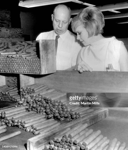American comedienne, actress, singer and businesswoman Edie Adams , gets a close look on cigar shading operations from Samuel J. Silberman at a...