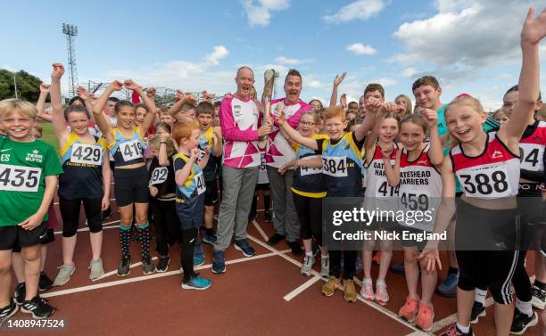 Batonbearers Phil Gallagher and Ian Goulding hold the Queen's Baton with local athletic clubs during the Birmingham 2022 Queen's Baton Relay on July...