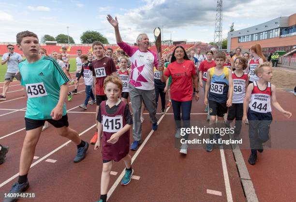 Batonbearer Sir Brendan Foster and Olympian Angela Gilmour with children from local athletic clubs during the Birmingham 2022 Queen's Baton Relay on...