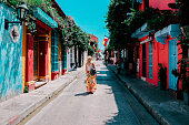 Young woman walking on a street of historical city of Cartagena, Colombia