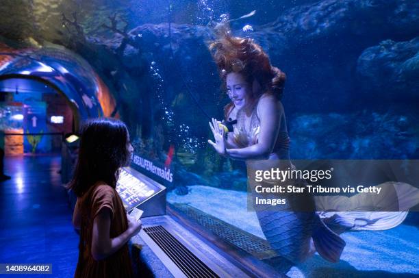 Kennocha Vang interacts with Citrine, a mermaid, Thursday, July 14, 2022 at Sea Life at Mall of America in Bloomington, Minn. This is the mermaids...