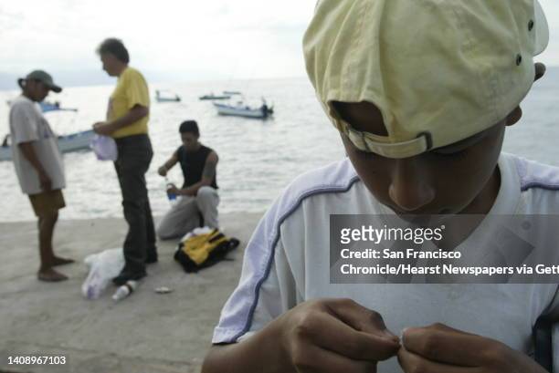 Roberto Carlos Montes Cantor is 14 and homeless. He spends his days fishing off the pier at Playa De Los Muertos with a fishing line tied around an...