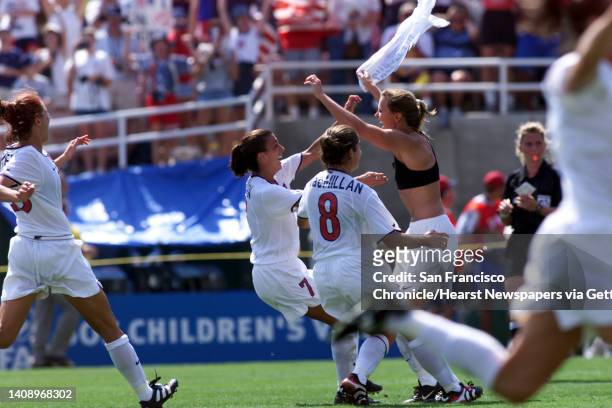 Women's world cup soccer team members rush Brandi Chastain after she made the final penalty kick to put the U. S. Women's team up by one penalty kick...