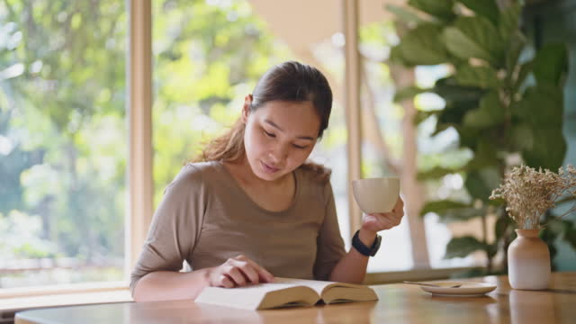 Woman reading a book and take a coffee in relax time