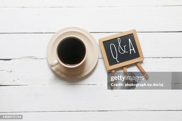 cup of coffee and mini blackboard with letter q and a - questions and answers stock pictures, royalty-free photos & images