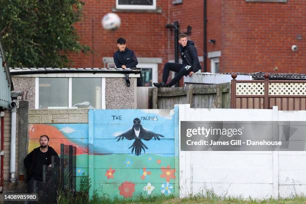 Two Chorley supporters watch the match from a nearby garden during the pre-season friendly match between Chorley and Stockport County at Victory Park...