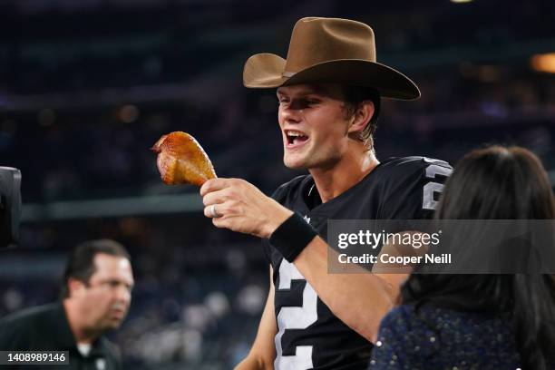 Daniel Carlson of the Las Vegas Raiders eats a turkey leg against the Dallas Cowboys after an NFL game at AT&T Stadium on November 25, 2021 in...