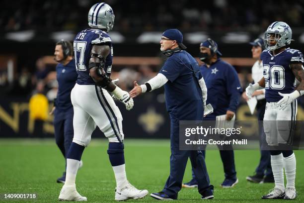 Tyron Smith of the Dallas Cowboys celebrates with defensive coordinator Dan Quinn against the New Orleans Saints during an NFL game at Caesars...