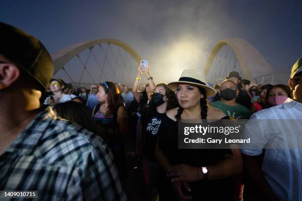 At night amidst a capacity audience a young woman in a panama hat and braids listens intently to the music of the band Ozomatli during the opening of...